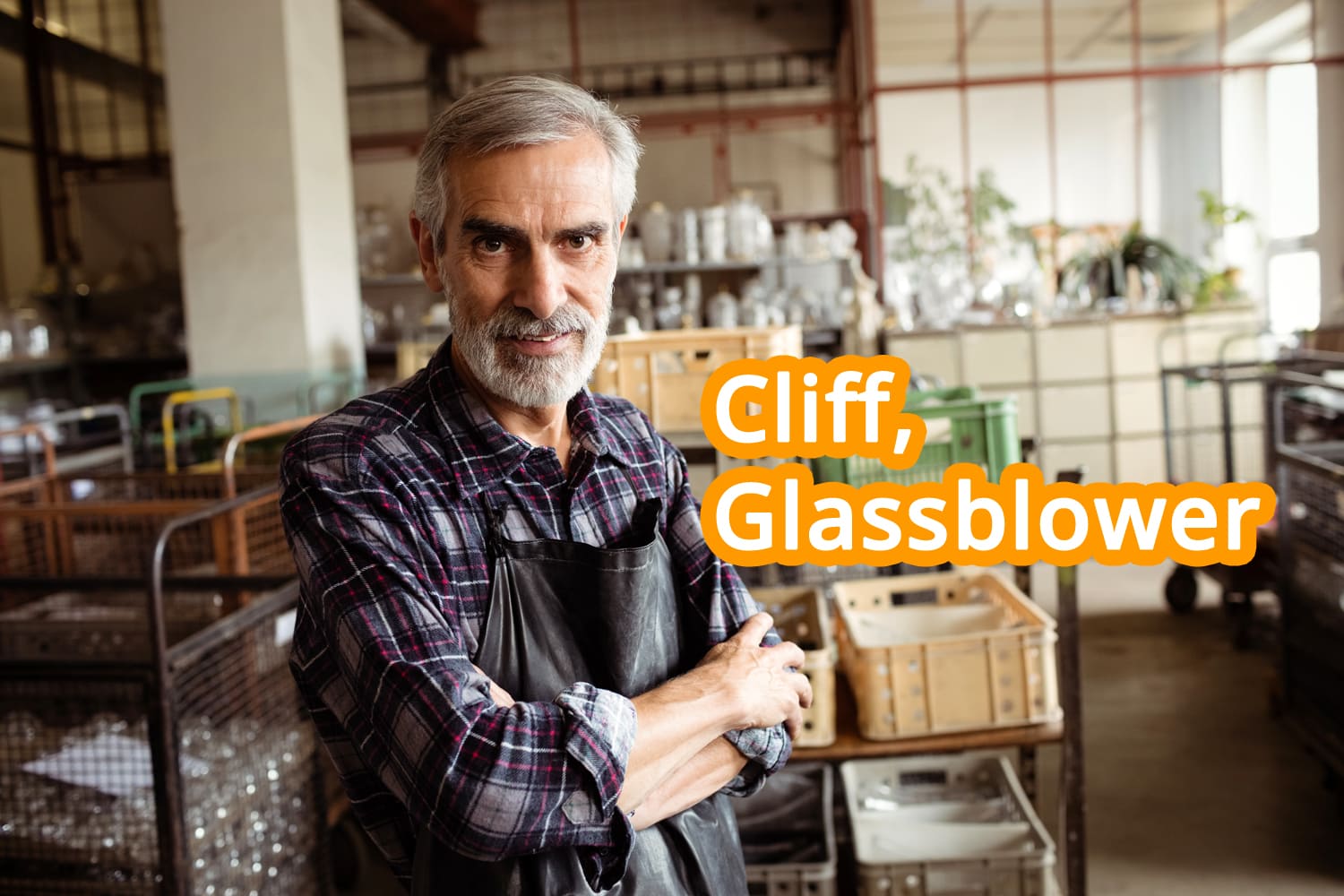 Glassblower stanting with arms crossed in his factory